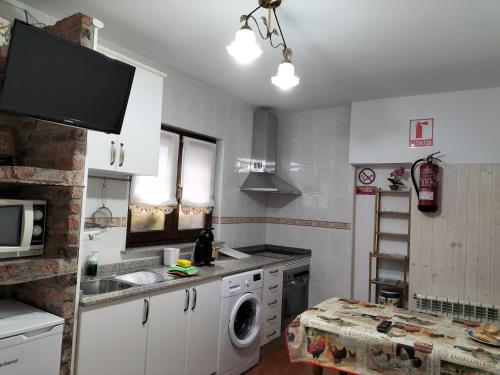 uma cozinha com um lavatório e uma máquina de lavar roupa em V.V Casa Mones em Cangas de Onís