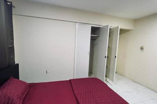 a bedroom with a red bed and a closet at 1 Room in apartment available for rent dating not allowd in Sharjah