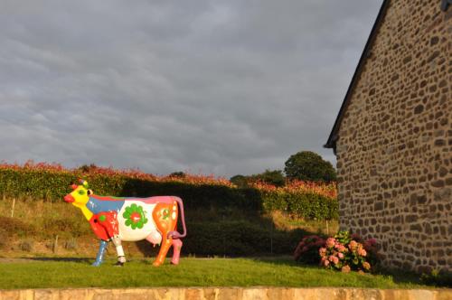 a statue of a cow standing in the grass at Maison la Quentinière in Saint-Calais-du-Désert