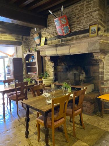 a dining room with a table and a fireplace at Hostellerie Du Chateau in Châteauneuf