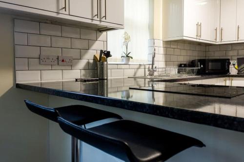une chaise noire assise sur un comptoir dans une cuisine dans l'établissement Large 4 Bed, En Suite Free Parking, à Walton on the Hill