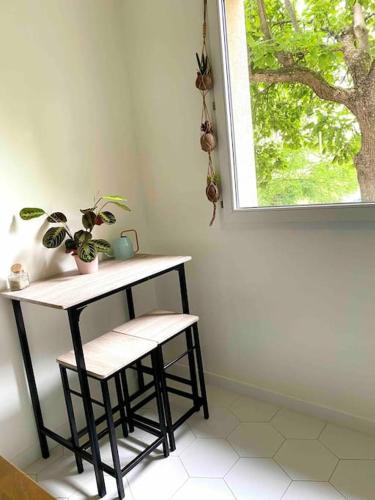 a table and stool in a room with a window at Mon cocoon toulousain cosy appartement idéalement situé in Toulouse
