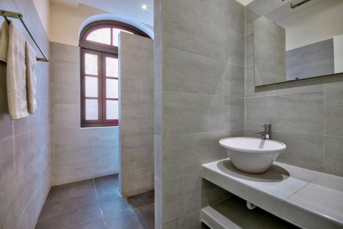 une salle de bain avec un lavabo et une fenêtre dans l'établissement Lucky Star 103 by Vallettastay, à La Valette