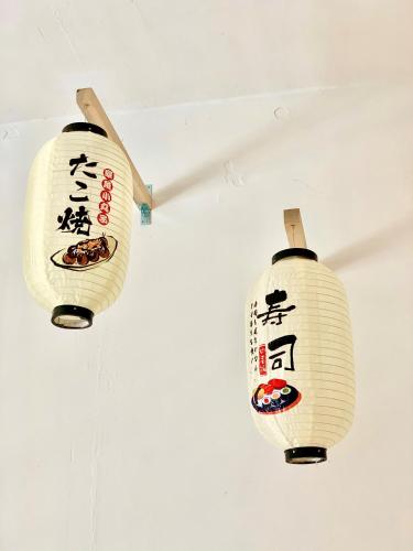 two lanterns with asian writing on them hanging from a ceiling at Deco Home @ Imago The Loft in Kota Kinabalu