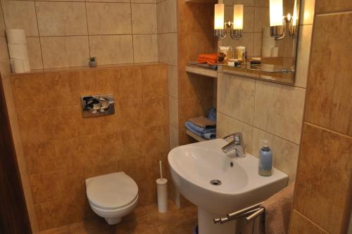 a small bathroom with a sink and a toilet at Apartament Bażantowo in Katowice