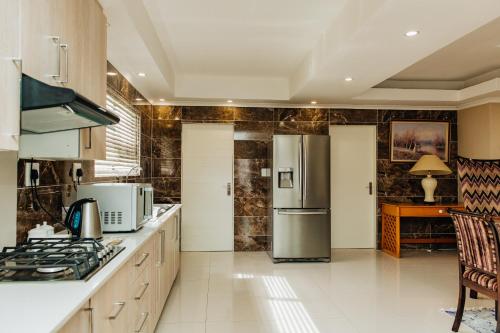 a kitchen with a stainless steel refrigerator and a table at Gosheni Villas in White River