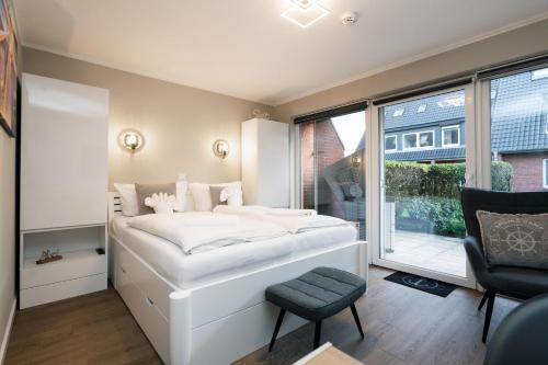 ein Schlafzimmer mit einem weißen Bett und einem Fenster in der Unterkunft Sylter Rose in Westerland