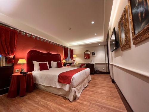 a bedroom with a large bed and a red wall at Ruzzini Palace Hotel in Venice