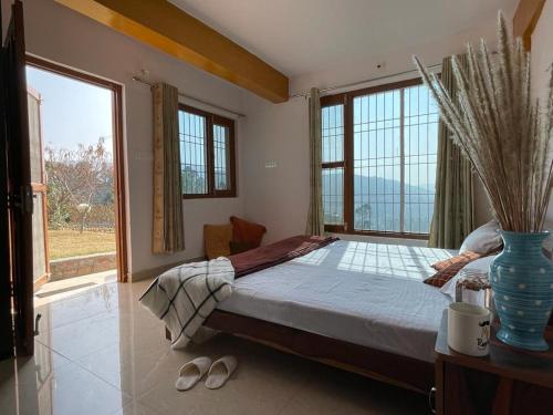 a bedroom with a bed and a large window at ValleyView Homestay in Mukteswar