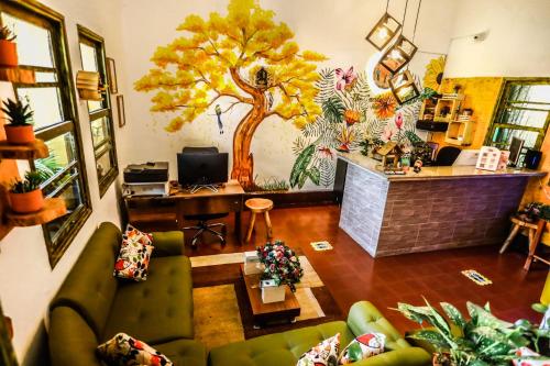 a living room with a tree mural on the wall at Hostal The Garden Lleras 10 in Medellín