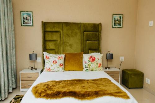 a bedroom with a large bed with a fur blanket at Gosheni Villas in White River
