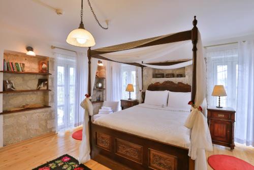 a bedroom with a large bed with a canopy at Stone Villa,Large Garden,Swimming Pool, Very Close the Beautiful Beach . in Cesme