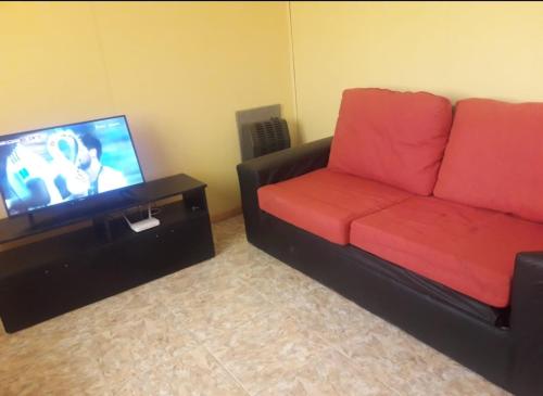 sala de estar con sofá y TV de pantalla plana en cba en El Calafate