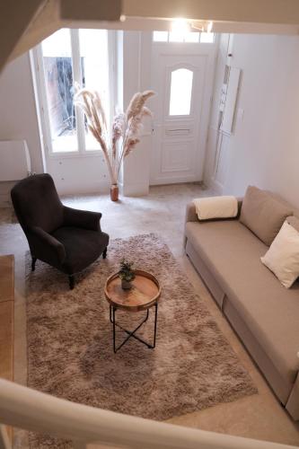 a living room with a couch and a chair and a table at Gîte le petit écolier in Lectoure