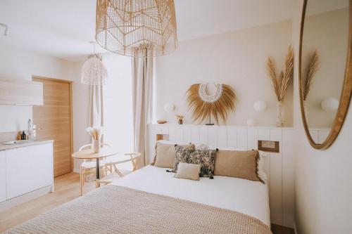 sypialnia z białym łóżkiem i stołem w obiekcie Apparts'hôtel l'Europe - centre gare- w Saint-Malo