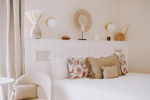 een witte slaapkamer met een witte bank en een spiegel bij Apparts'hôtel l'Europe - centre gare- in Saint-Malo