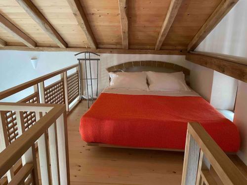 ein Schlafzimmer mit einem roten Bett auf einem Holzboden in der Unterkunft MONOVASIA SUITES Anopolis in Monemvasia