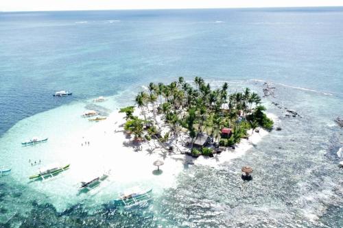 an island in the ocean with people in the water at Entire Island home with HighSpeed Internet and gated parking in Dapa