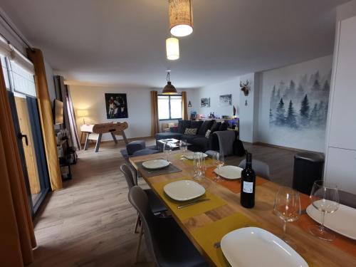 - une salle à manger et un salon avec une table et des verres à vin dans l'établissement Le Boréal - Chalet des Etoiles, à Bagnères-de-Bigorre
