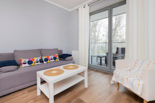 a living room with a couch and a table at Gdańsk Krasickiego Apartments by the Beach by Renters in Gdańsk