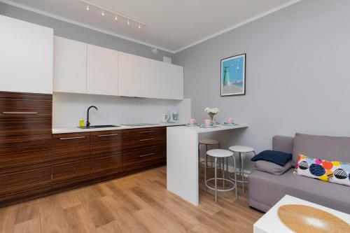 a kitchen and a living room with a couch at Gdańsk Krasickiego Apartments by the Beach by Renters in Gdańsk