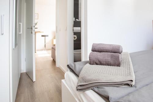 1 dormitorio con paredes blancas y 1 cama con toallas en boardinghouse44, en Georgsmarienhütte