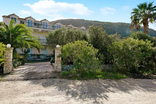 a house with a palm tree in front of it at Dolphin Apartment Sea View 9 in Keri