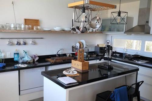 a kitchen with a black counter top and white cabinets at La Juanita Jose Ignacio in José Ignacio