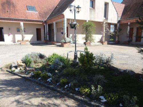 a garden in the courtyard of a building at Logis Hotel Le Nuage in La Bussière