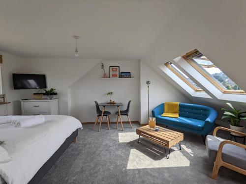 a bedroom with a bed and a blue couch and a table at *Large Unique Retro Private Attic & Bathroom* in Brighton & Hove