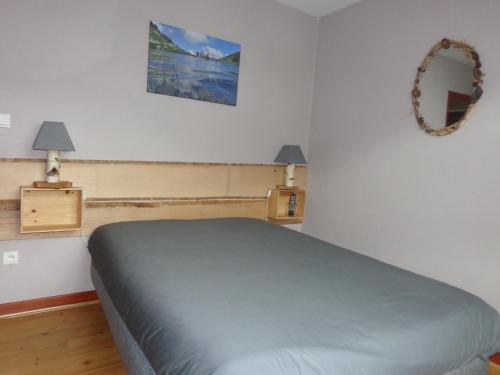吕兹-圣索沃尔Chez Corine Marque Bastampe的卧室里有一张床，墙上有一面镜子