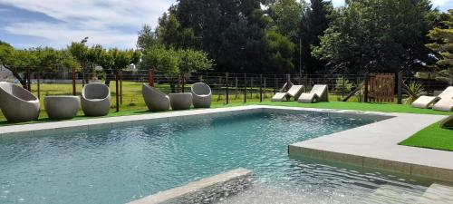 a swimming pool with lounge chairs in a yard at Ak´Para in Tandil