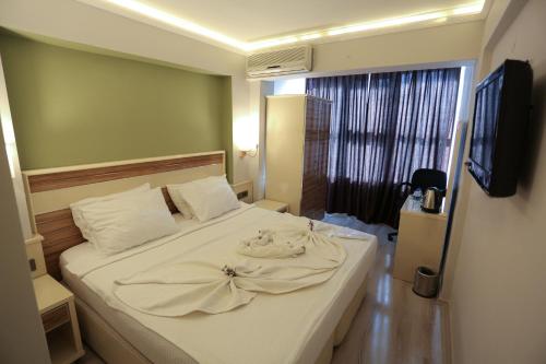 a bedroom with a bed with a towel on it at BEST SMYRNA HOTEL in Aydın