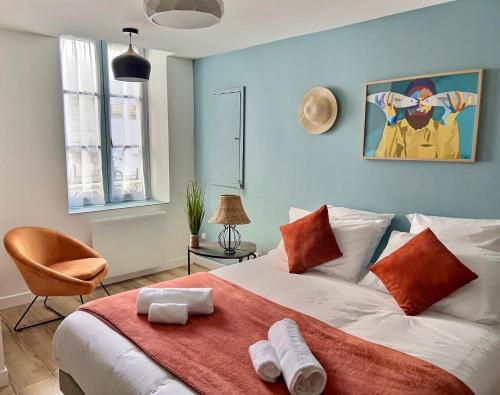 - une chambre avec un lit blanc et une couverture orange dans l'établissement Loc'Ouest 17, à La Rochelle