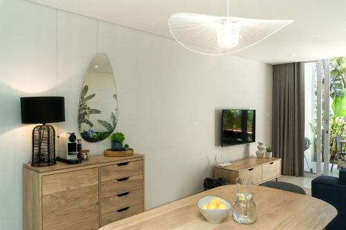 a living room with a table and a surfboard on the wall at Newly renovated stylish Mallorca Apartment in Umdloti