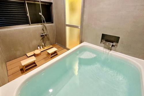 baño con una gran bañera azul con ventana en 加美屋リゾート奥多摩 テラス＆風呂 en Ome