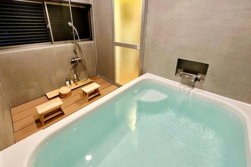 青梅市にある加美屋リゾート奥多摩 テラス & 風呂-Kamiya Resort Okutamaのバスルーム(窓のある大きな青いバスタブ付)
