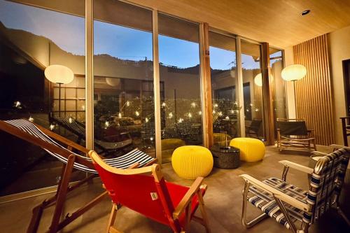 a room with chairs and a large window with a view at 加美屋リゾート奥多摩 テラス & 風呂-Kamiya Resort Okutama in Ome