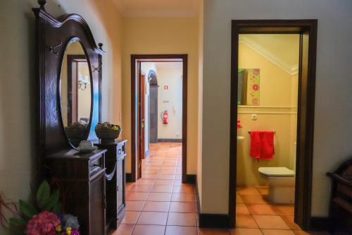 a hallway with a bathroom with a toilet and a mirror at Bella Italia Pópulo Guest House in Ponta Delgada