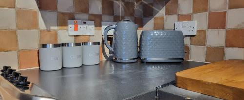 three coffee mugs sitting on top of a counter at Cosy Stays Daybrook in Nottingham