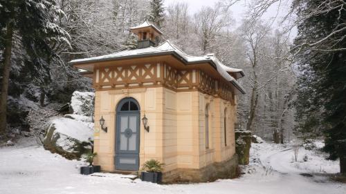 a small building with a roof in the snow at Ferienwohnung Jagdschloss Bielatal in Bielatal