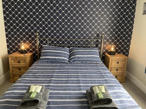 sypialnia z niebiesko-białym łóżkiem z 2 stolikami nocnymi w obiekcie Middle Deal Cottage w mieście Deal