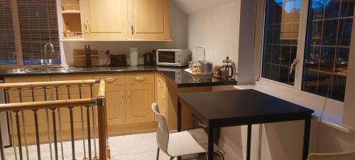 a small kitchen with a table and a microwave at Peaceful self contained Studio in lovely garden. in Hinckley