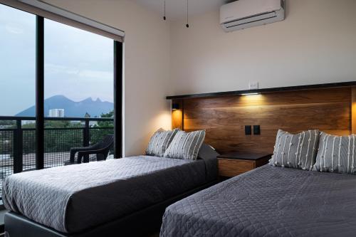 um quarto com 2 camas e uma grande janela em Cerca de UANL, equipado y lujoso en Tulancingo 10 em Monterrey