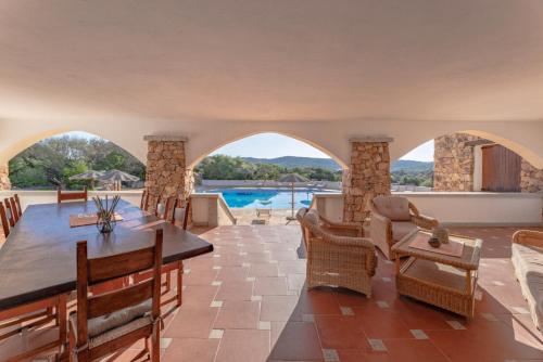uma sala de estar com mesa e cadeiras e uma piscina em Villa Antonina em Porto Rotondo