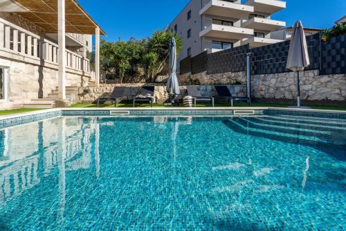 a swimming pool in front of a building at Villa Moreta with heated pool, Sauna, Hot-tub in Trogir
