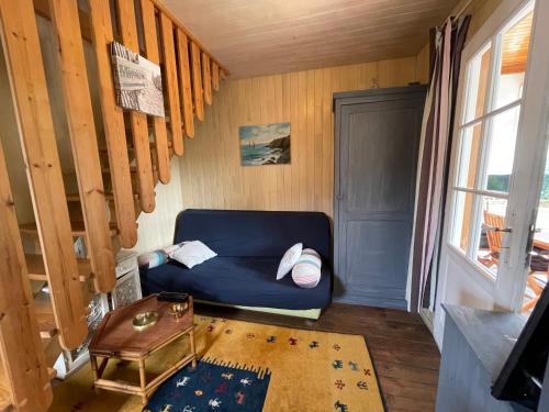 un salon avec un canapé bleu et une fenêtre dans l'établissement L'Ecureuil, à Mimizan