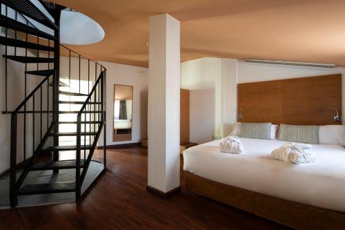 a bedroom with a bed and a spiral staircase at Petit Palace Plaza Málaga in Málaga