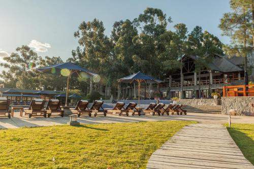 a group of benches and umbrellas in a park at Carmelo Resort & Spa in Carmelo