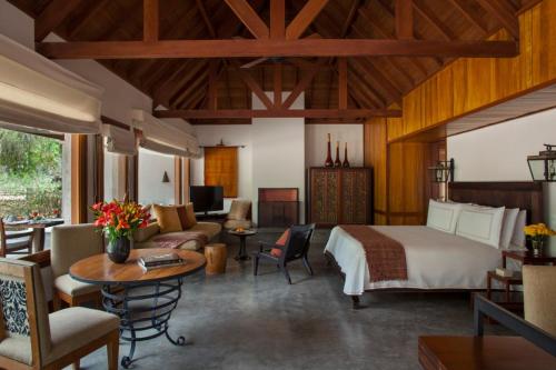 Carmelo Resort & Spa في كارميلو: غرفة نوم مع سرير وغرفة معيشة